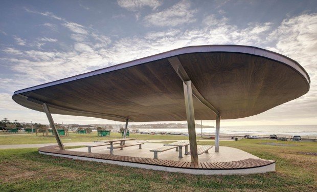 Coastal shelter with a curved cantilevered roof on tapered columns