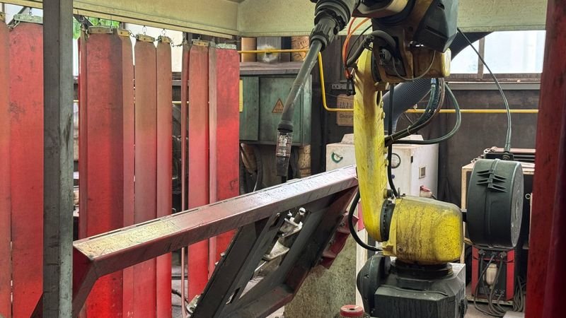 Welding robot positioned at a steel section in a fixture